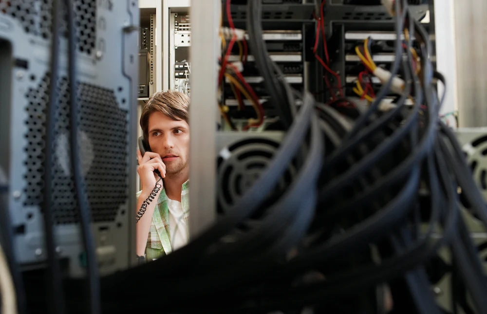IT technician organizing ethernet cables during a network cabling installation